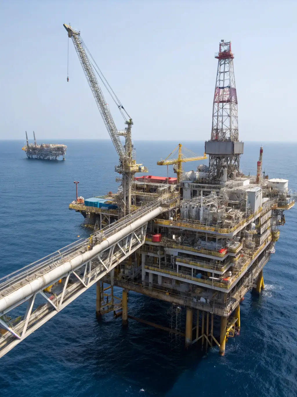 An image of offshore oil rigs and exploration equipment set against a clear sky, symbolizing energy extraction.